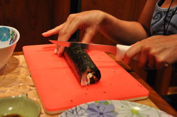 Ritual de preparação de sushi. Passo 4:  Depois de enrolar a folha de alga com arroz amassado ao redor do recheio, cortar tudo bem fininho. Pronto! Já temos suhis deliciosos!    (Cidade do Panamá)